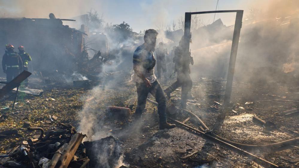 Emergency workers amid rubble after a Russian strike on a Kharkiv energy site