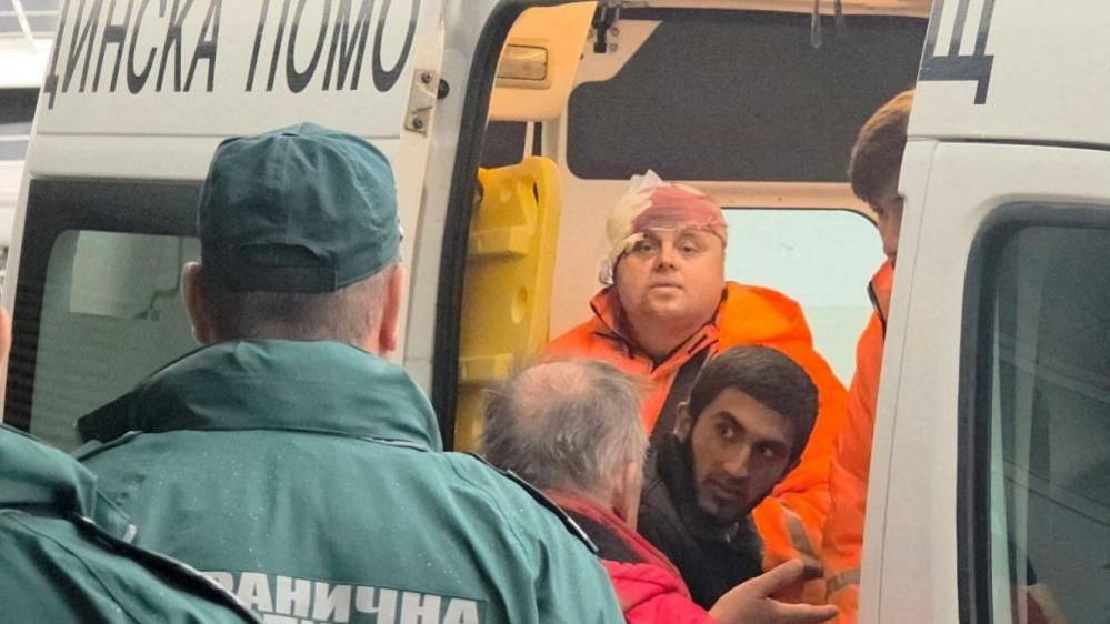 Rescued crew members on a damaged ship after drone strike